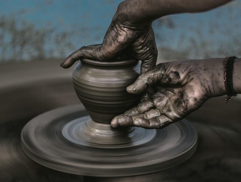 Manos trabajando arcilla en el torno