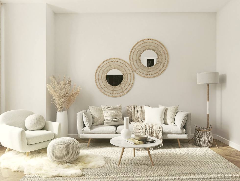 Sala luminosa con sillones claros y plantas