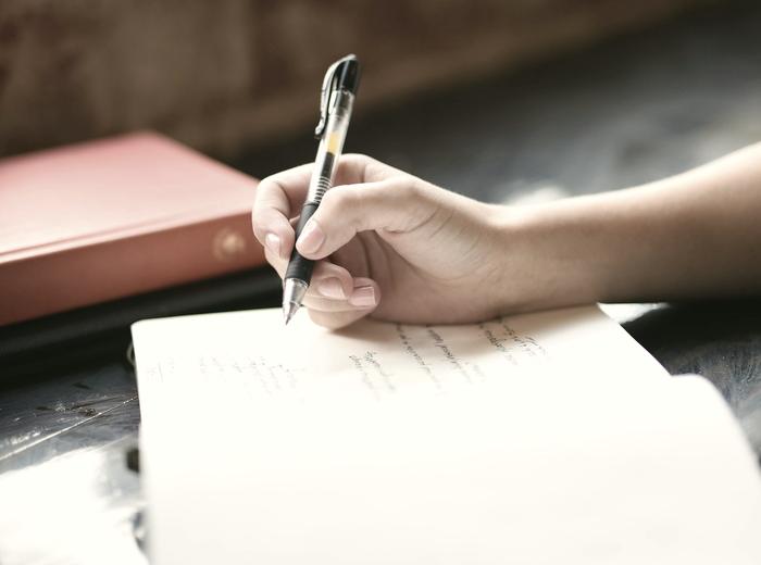Manos escribiendo en un cuaderno